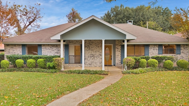 ranch-style house with a front yard and covered porch