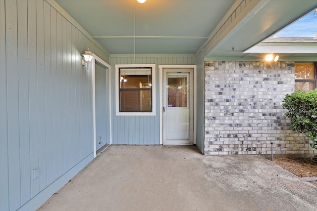 view of exterior entry with a patio area