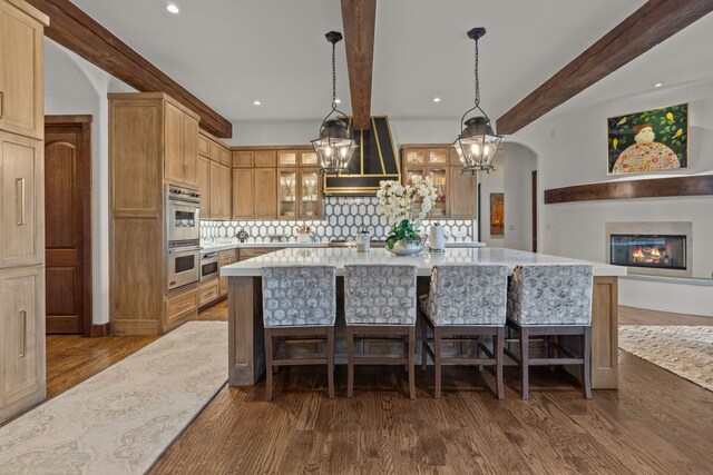 kitchen featuring hanging light fixtures, a chandelier, light wood-type flooring, stainless steel appliances, and sink