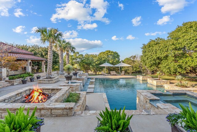 view of pool featuring an outdoor fire pit, a patio area, and an in ground hot tub