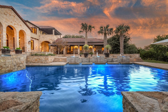 pool at dusk with a patio