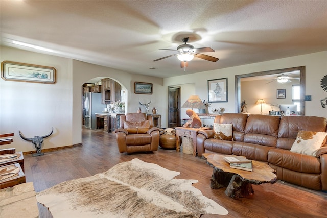 living room with ceiling fan, wood-type flooring, and a textured ceiling