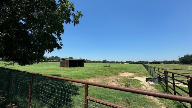 view of yard with an outbuilding and a rural view