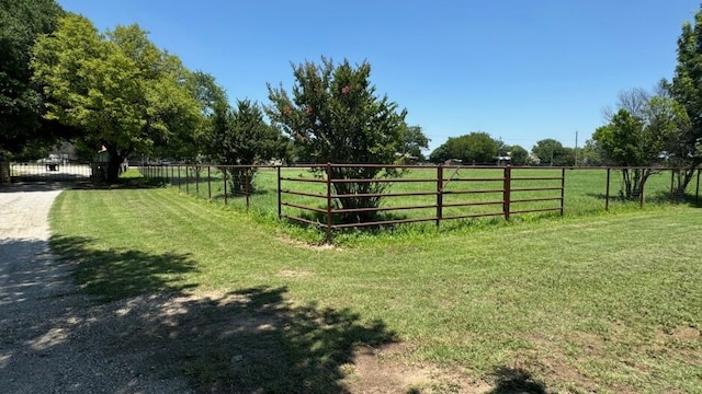 view of gate featuring a lawn and a rural view