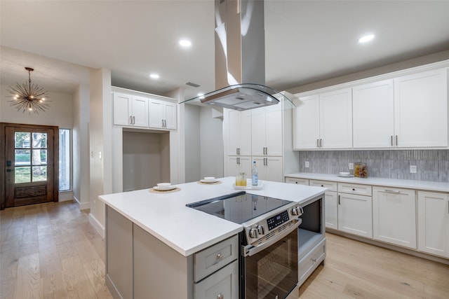 kitchen with white cabinetry, stainless steel electric stove, light wood-type flooring, and extractor fan