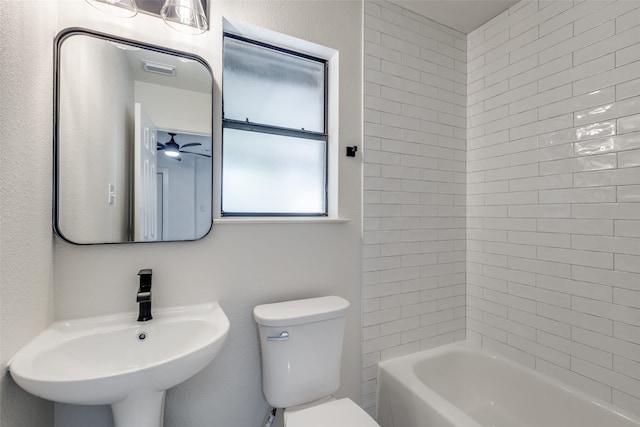 full bathroom featuring toilet, tiled shower / bath combo, sink, and ceiling fan