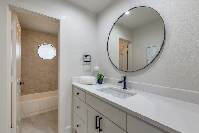 bathroom featuring vanity and tiled shower / bath