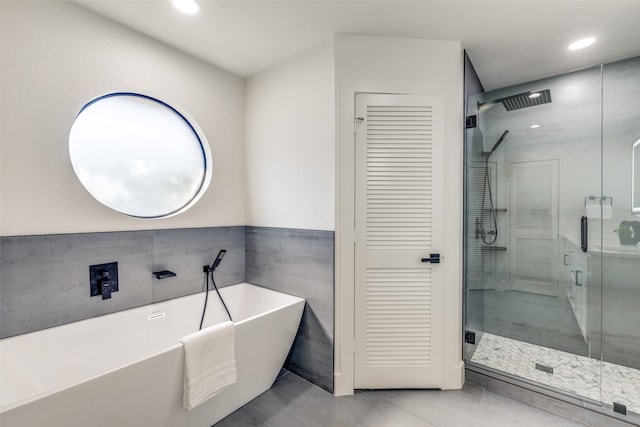 bathroom featuring tile patterned floors, tile walls, and plus walk in shower