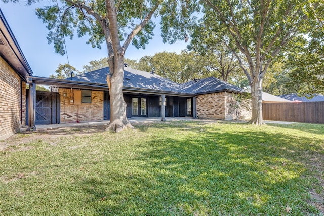 rear view of property with a lawn