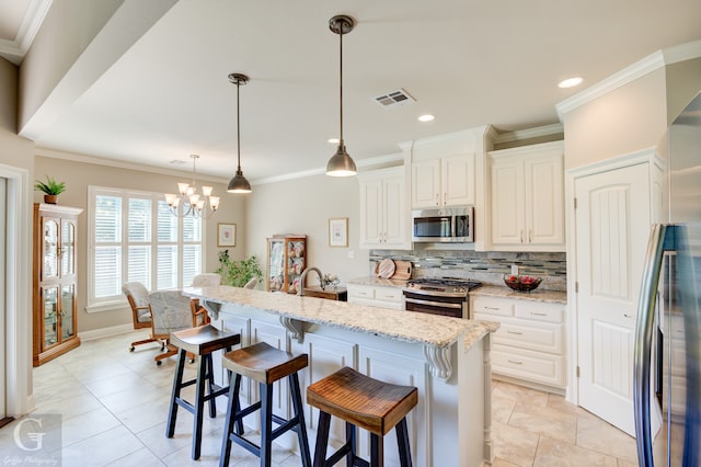 kitchen with a breakfast bar area, stainless steel appliances, decorative light fixtures, white cabinets, and light stone counters