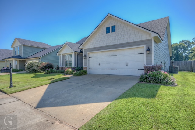 view of front facade with a garage, a front lawn, and central air condition unit