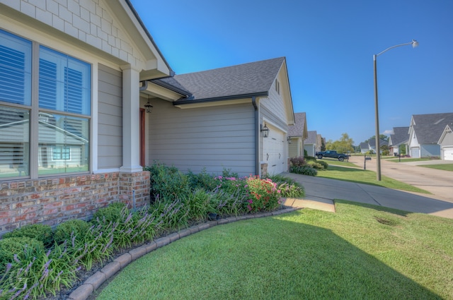 view of side of property featuring a lawn and a garage