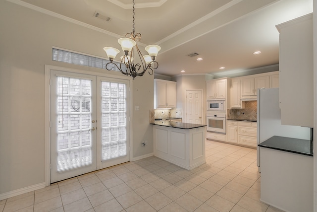 kitchen with white appliances, decorative backsplash, light tile patterned floors, a notable chandelier, and white cabinetry