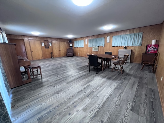 dining area with wooden walls and wood-type flooring