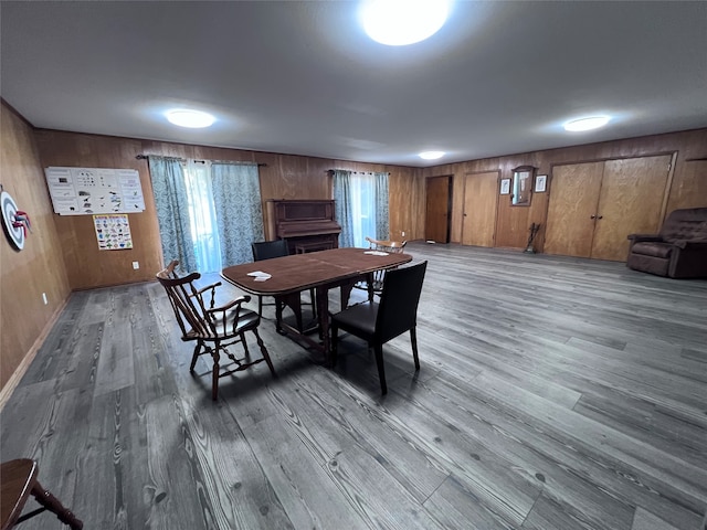 dining room featuring hardwood / wood-style floors and wood walls