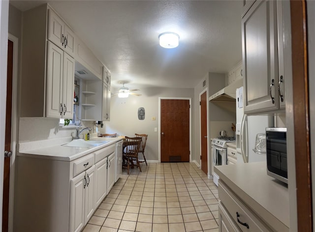 kitchen featuring white cabinetry, sink, and white gas range