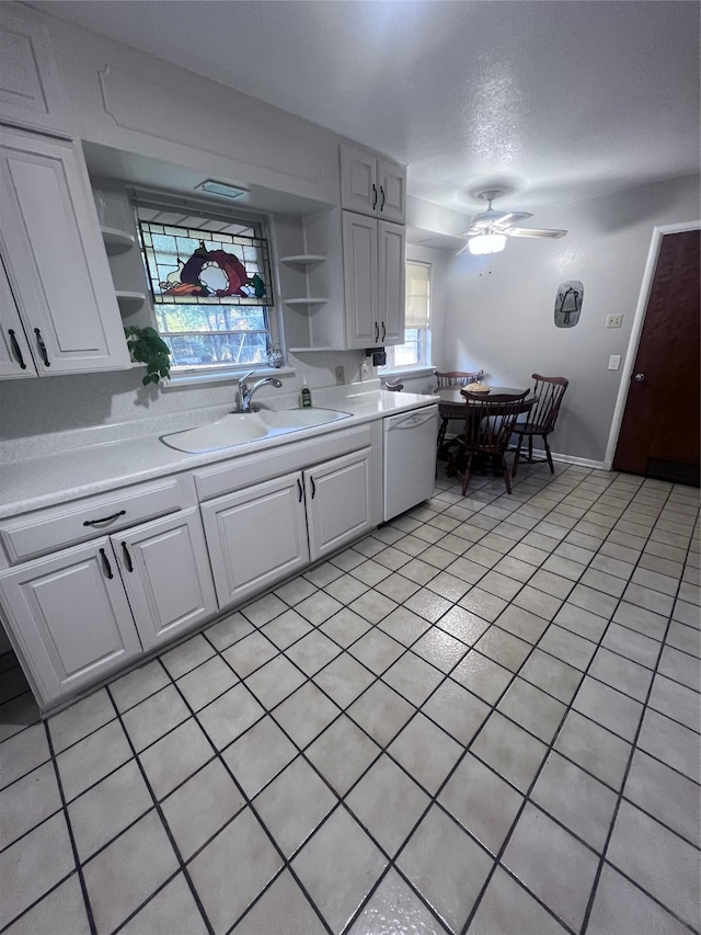 kitchen featuring white cabinets, dishwasher, sink, and light tile patterned floors