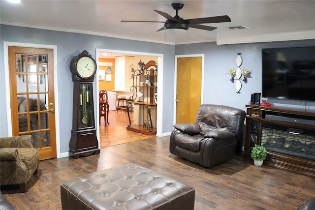 living room with ceiling fan, crown molding, and wood-type flooring