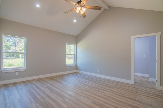 unfurnished room with beamed ceiling, high vaulted ceiling, light hardwood / wood-style floors, and a wealth of natural light