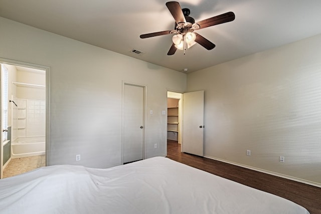 bedroom featuring connected bathroom, ceiling fan, a closet, and dark hardwood / wood-style floors