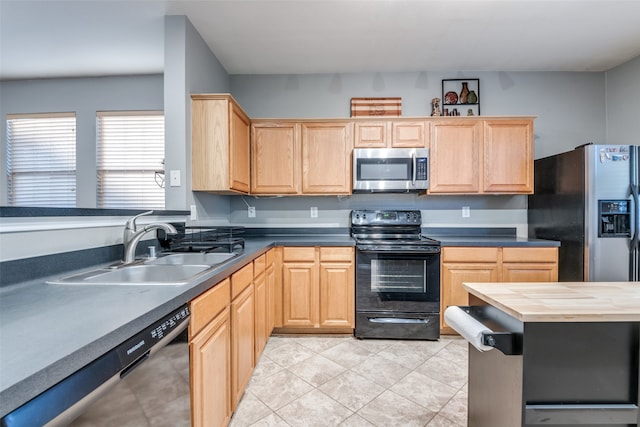 kitchen with light brown cabinetry, appliances with stainless steel finishes, sink, and wooden counters