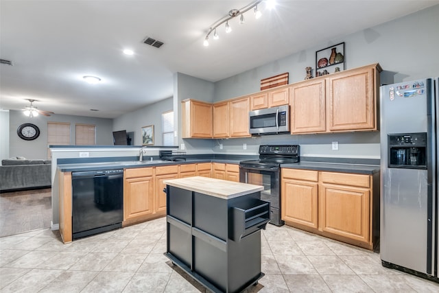 kitchen with light brown cabinetry, black appliances, a kitchen island, and ceiling fan