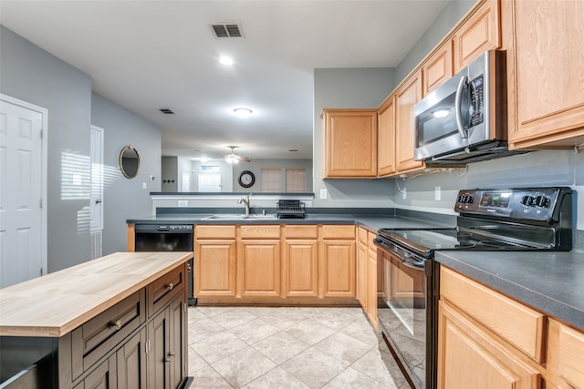 kitchen featuring light brown cabinetry, butcher block counters, light tile patterned flooring, black appliances, and sink