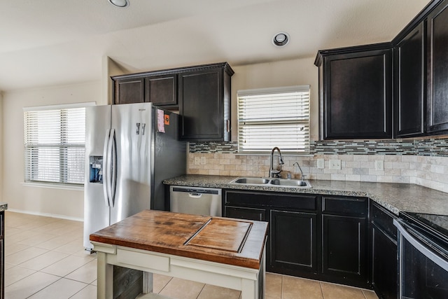 kitchen featuring decorative backsplash, sink, stainless steel appliances, and light tile patterned flooring