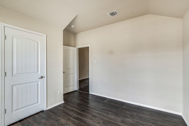 unfurnished bedroom featuring dark hardwood / wood-style flooring and vaulted ceiling