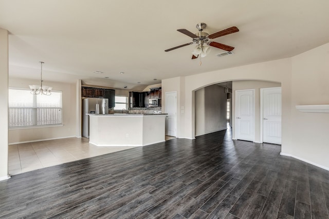 unfurnished living room with ceiling fan with notable chandelier, sink, and dark hardwood / wood-style flooring