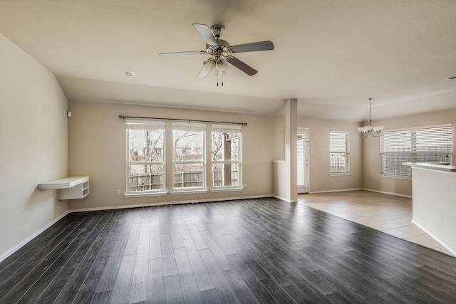 unfurnished living room with dark wood-type flooring and ceiling fan with notable chandelier