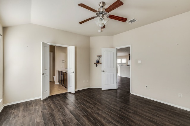 interior space featuring ceiling fan, dark hardwood / wood-style floors, connected bathroom, and lofted ceiling