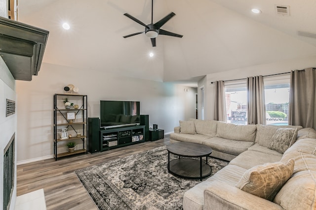 living room with light hardwood / wood-style flooring, high vaulted ceiling, and ceiling fan