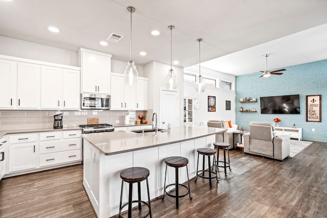 kitchen featuring a center island with sink, sink, white cabinetry, and stainless steel appliances