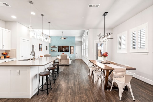 dining room featuring ceiling fan, dark wood-type flooring, and sink