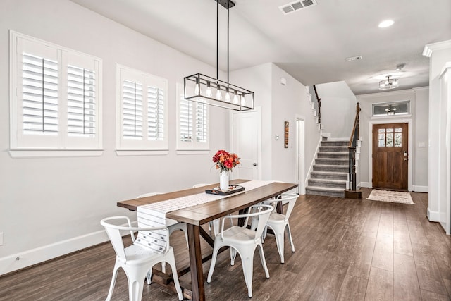 dining room with crown molding, plenty of natural light, and dark wood-type flooring