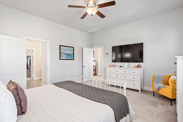 carpeted bedroom with ceiling fan, a spacious closet, and a closet