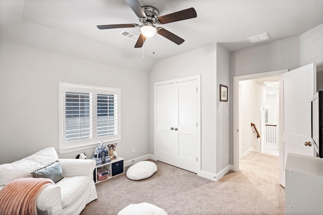 living area with ceiling fan, light colored carpet, and vaulted ceiling