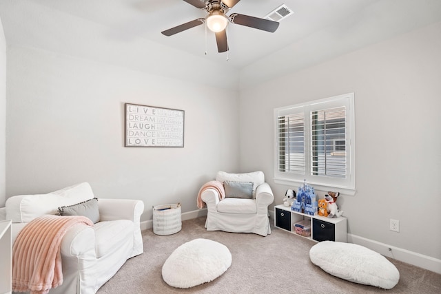 living area featuring carpet flooring and ceiling fan