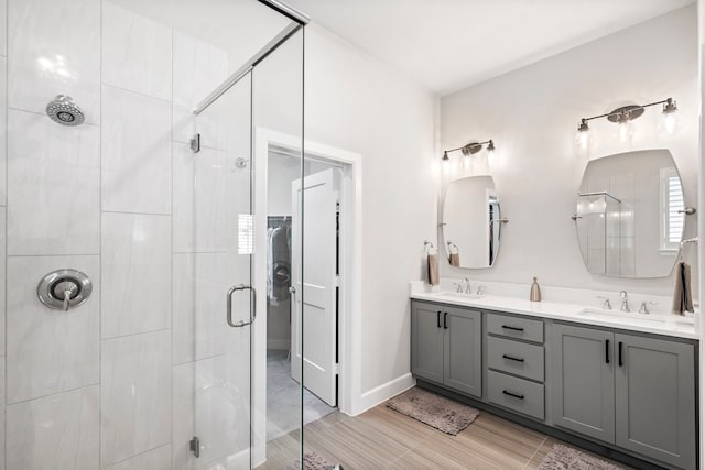 bathroom with hardwood / wood-style floors, vanity, and a shower with shower door