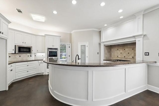 kitchen with kitchen peninsula, backsplash, ornamental molding, stainless steel appliances, and white cabinets