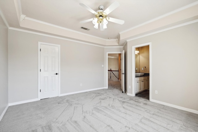 unfurnished bedroom with ensuite bathroom, ceiling fan, crown molding, and light carpet