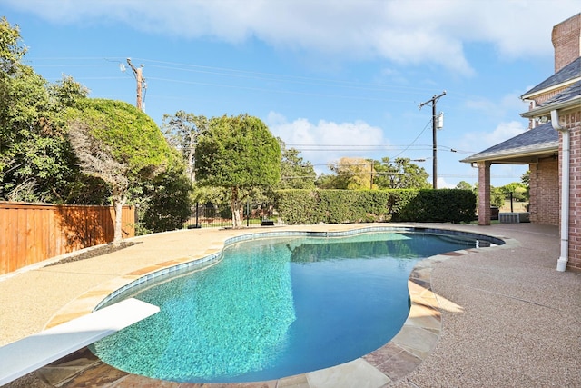 view of swimming pool with a patio area and a diving board