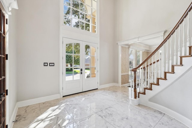 foyer featuring a wealth of natural light, french doors, and a high ceiling