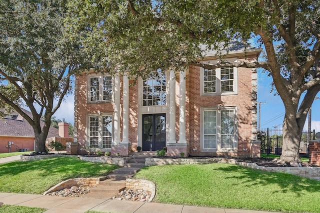 view of front facade with french doors and a front lawn