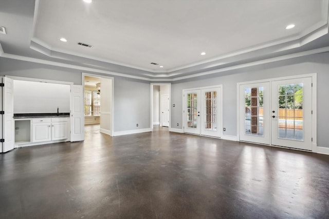 unfurnished living room with french doors, a raised ceiling, ornamental molding, and sink