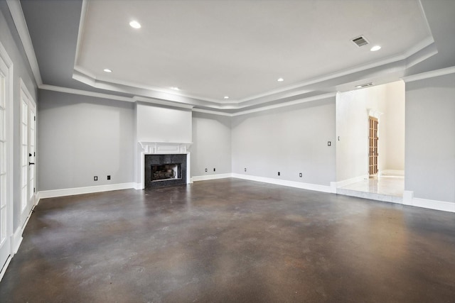 unfurnished living room with a tray ceiling, ornamental molding, and a premium fireplace