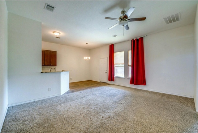 unfurnished living room with light carpet and ceiling fan with notable chandelier