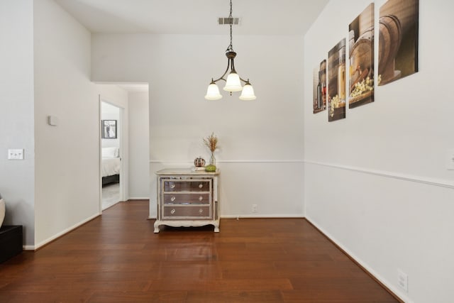 hallway with a chandelier and dark hardwood / wood-style flooring