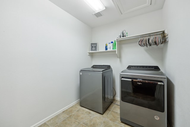 laundry area featuring light tile patterned floors and washer and clothes dryer